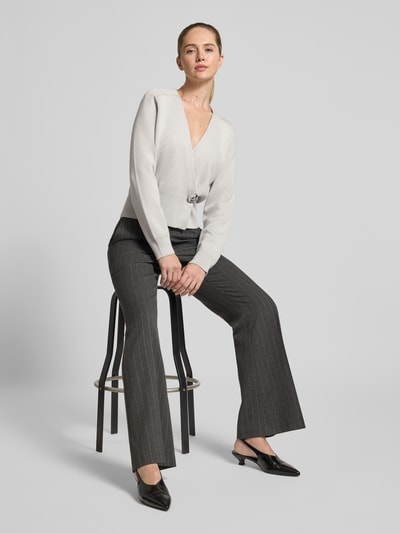 Frauenmodel trägt Cardigan im Wickel-Look - curated by Isabelle Hartmann von Style Icon Collection, grauer Ton, gerippte Ärmelabschlüsse, Knopfverschluss, V-Ausschnitt, Lockere-Schnitt, Rückenlänge 54 cm, Ärmellänge 62 cm, Ganzkörperansicht von vorne.