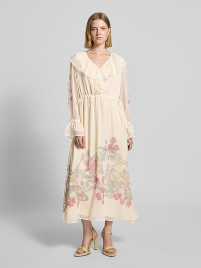Frauenmodel trägt Maxikleid mit Rüschenärmeln von Comma aus Chiffon, Farbton Creme mit floralen Details, Taillierter Schnitt, V-Ausschnitt mit Volant, Rückenlänge 131 cm, Brustweite 50 cm, Ärmellänge 60 cm, Ganzkörperansicht von vorne.