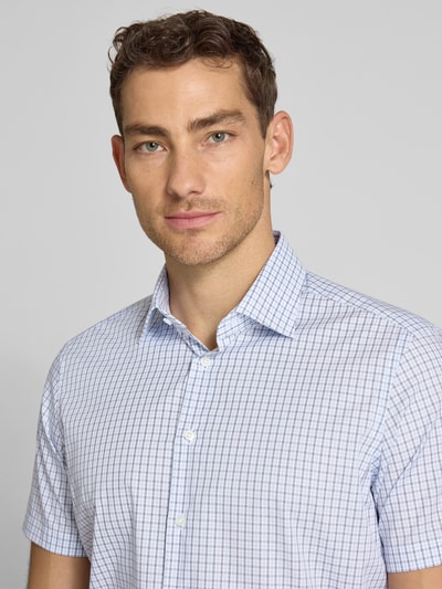 Männermodel trägt Regular Fit Business-Hemd aus Baumwolle mit Kentkragen von Christian Berg Men im karierten Allover-Look, Nahaufnahme Oberkörper.