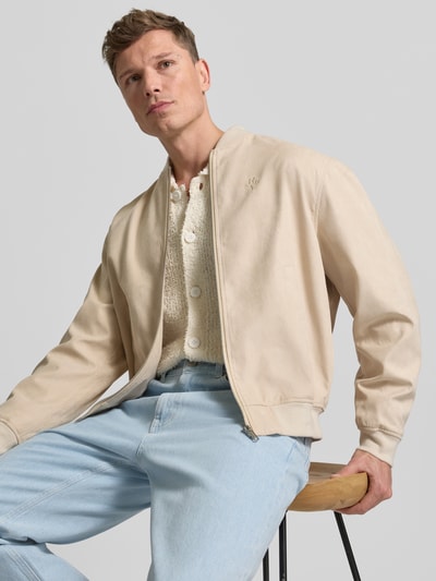 Männermodel trägt Bomberjacke mit Reißverschluss von REVIEW in Beige mit Stehkragen, gerippten Abschlüssen, Eingrifftaschen, Nahaufnahme Oberkörper.