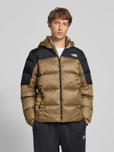Männermodel trägt Regular Fit Jacke in Stepp-Optik Modell 'Diabolo' von The North Face in Braun und Schwarz mit Logo-Stitching, Ganzkörperansicht von vorne.