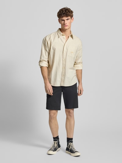 Männermodel trägt Regular Fit Chino Shorts aus Baumwoll-Mix von Levi's®, Schwarz, Eingrifftaschen, Ganzkörperansicht von vorne.