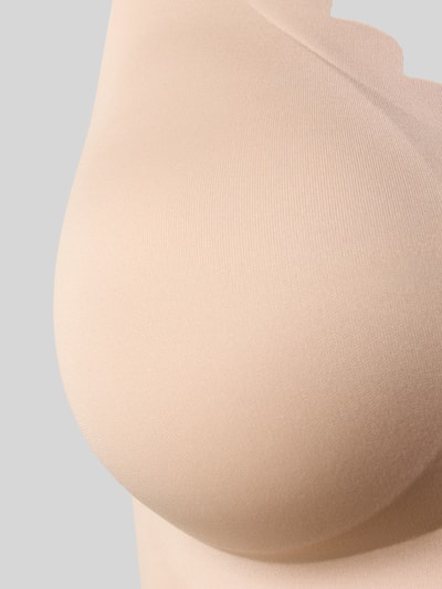 Frauenmodel trägt Unterhemd mit Wellensaum und herausnehmbaren Pads von Skiny aus Material-Mix mit Stretch-Anteil, Detailaufnahme.