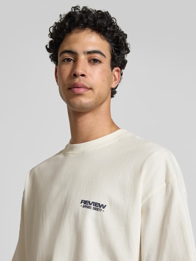 Männermodel trägt T-Shirt mit Rundhalsausschnitt und Logo-Print von REVIEW, Herren T-Shirt aus Reine Baumwolle, Modern Fit, Nahaufnahme Oberkörper.