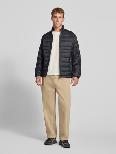 Męski model nosi Regular Fit kurtkę w stylu pikowanym Model 'Kingsley' od JACK & JONES, kolor czarny, zamek błyskawiczny, wpuszczane kieszenie, stójka, długość tyłu w rozmiarze M: 72 cm, szerokość ramion w rozmiarze M: 48 cm, szerokość klatki piersiowej w rozmiarze M: 51 cm, długość rękawów w rozmiarze M: 68 cm, pełny widok z przodu.