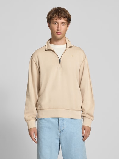 Männermodel trägt Regular Fit Sweatshirt aus reiner Baumwolle von G-Star RAW in Beige, kombiniert mit Jeans, Ganzkörperansicht von vorne.