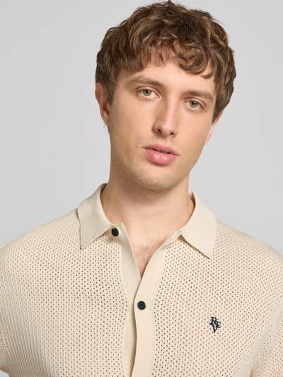 Männermodel trägt Slim Fit Strick-Poloshirt mit Label-Stitching von REVIEW, Viskose-Mix, Kontraststreifen, Knopfleiste, Nahaufnahme Oberkörper.