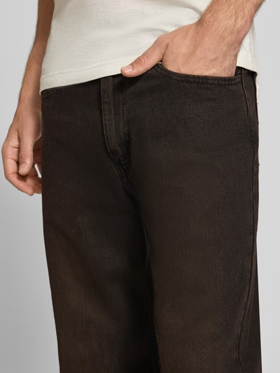 Männermodel trägt dunkelbraune Loose Fit Jeans aus reiner Baumwolle Modell '565®' von Levi's®, Herrenjeans, Nahaufnahme Oberkörper.