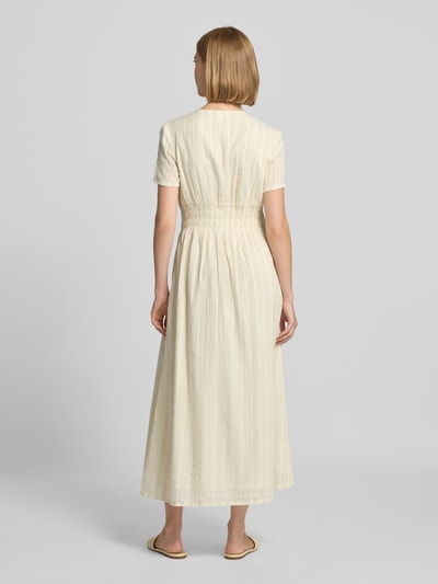Frauenmodel trägt Midikleid mit V-Ausschnitt und Knopfleiste von Jake*s Studio Woman aus Baumwoll-Mix in Creme mit feiner Struktur, Ganzkörperansicht Rückansicht.