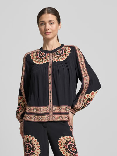 Frauenmodel trägt Relaxed Fit Bluse mit Rundhalsausschnitt Modell 'VALDA' von Bash, Allover-Look, Reine Viskose, schwarze Grundfarbe, Ganzkörperansicht von vorne.