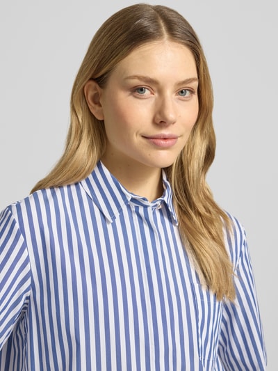 Modelka nosi Regular Fit Hemdbluse mit Umlegekragen Modell 'Bette' od JOOP!, elastyczna mieszanka bawełny, krój regular fit, półrękaw, kieszeń na piersi, kołnierz koszulowy, długość tyłu 52 cm w rozmiarze 36, długość rękawa 28 cm w rozmiarze 36, biało-niebieskie pionowe paski, widoczne gładkie faktury, zbliżenie na górną część ciała.