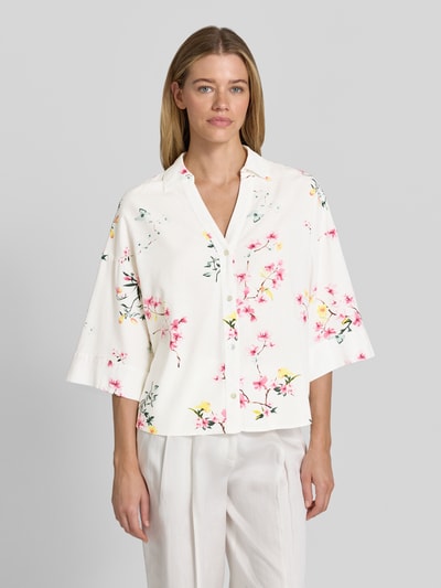 Vrouwenmodel draagt Relaxed Fit blouse uit mix van viscose en linnen model 'Lavisco' van FREE/QUENT, all-over look, witte stof met roze bloemen, overhemdkraag, V-hals, 3/4-mouw, ruglengte maat S 67 cm, mouwlengte maat S 30 cm, frontaal zicht buste-nabij.