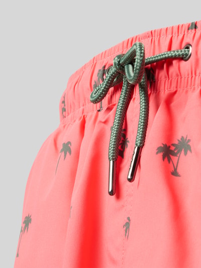 Produktfoto, Badehose mit elastischem Bund von MCNEAL in Koralle mit Palmenmuster, grünem Tunnelzug sowie Eingriff- und Gesäßtaschen, Detailaufnahme.