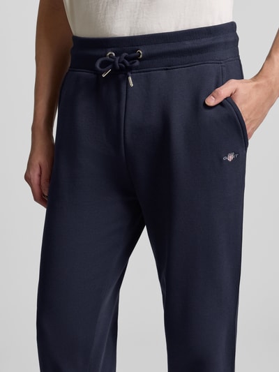 Männermodel trägt Sweatpants mit elastischem Bund von Gant, katoenmix, los model, steekzakken, tunnelkoord, donkerblauw, nahaufnahme taille