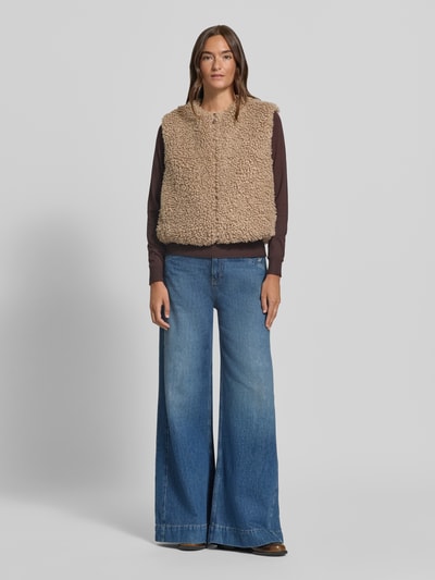 Frauenmodel trägt Relaxed Fit Weste mit Teddystruktur Modell 'Wikara' von OPUS in Beige, kombiniert mit blauer Jeans, Fleece aus Polyester, unifarben, Strukturmuster, Ganzkörperansicht von vorne.