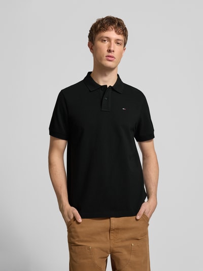 Męski model nosi Regular Fit Poloshirt aus reiner Baumwolle von Tommy Jeans, efekt: jednolity kolor, krój regular fit, wyhaftowane logo, kołnierzyk polo, krótki rękaw, wykończenie: z rozcięciami po bokach, pika, bawełna, zdjęcie: całkowity widok z przodu