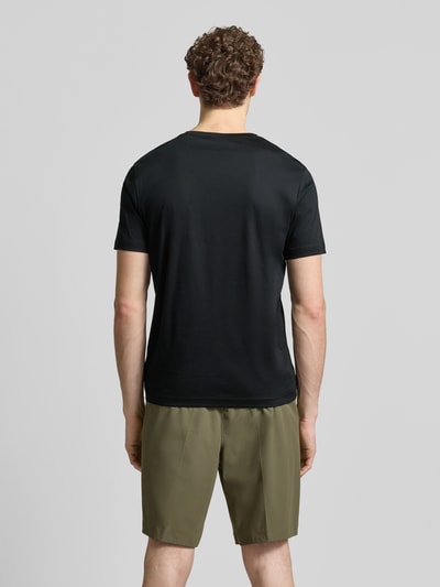 Männermodel trägt Regular Fit T-Shirt aus reiner Baumwolle Modell 'PS Spirit 70 Grx' von BOSS Green X PORSCHE in Schwarz, Ganzkörperansicht Rückansicht.