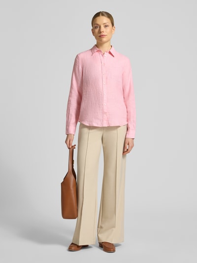 Modelka nosi Regular Fit Leinenbluse mit Label-Stitching von Gant z lnu w kolorze różowym, z kołnierzykiem koszulowym, listwą guzikową, długość tyłu 66 cm, długość rękawów 60 cm, krój regular fit, widok całej sylwetki od przodu.