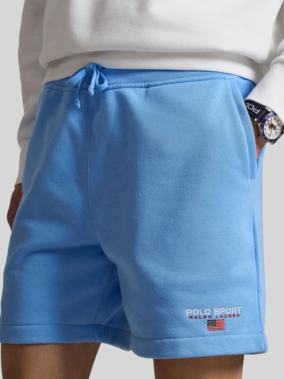 Mężczyznamodel nosi Regular Fit Sweatshorts aus Baumwoll-Mix von Polo Ralph Lauren, jasnoniebieskie, bawełniany miks, naszywka z logo, tunelowy ściągacz, elastyczny pas, kieszenie boczne i tylna, widok z przodu, zbliżenie na dolną część tułowia.