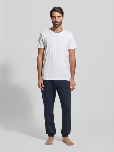 Männermodel trägt weißes T-Shirt mit Rundhalsausschnitt im 2er-Pack von Christian Berg Men in Slim Fit aus reiner Baumwolle, Ganzkörperansicht von vorne.