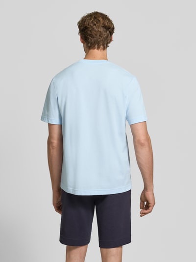 Męski model nosi Regular Fit T-Shirt aus reiner Baumwolle von Lacoste w jasnoniebieskim kolorze, gładka struktura, Ganzkörperansicht Rückansicht.