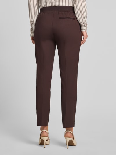 Frauenmodel trägt Regular Fit Marlenehose aus Viskose-Mix Modell 'TAPRIA-CROP' von BOSS, efekt: jednolity kolor, aplikacja z metką, zapięcie na haftkę i zamek błyskawiczny, elastyczny pas, boczne wpuszczane kieszenie, kieszeń z tyłu, wykończenie materiału: mieszanka wiskozy, kolor brązowy, Ganzkörperansicht Rückansicht.