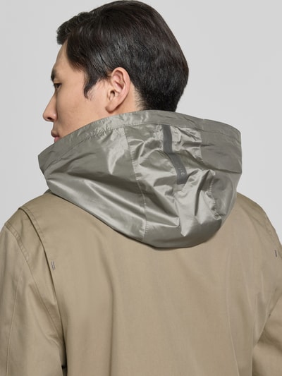 Männermodel trägt Jacke mit Stehkragen und Pattentaschen Modell 'DEFENDER' von G-LAB aus Baumwoll-Mix in Beige, Detailaufnahme Rückansicht.