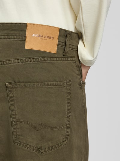 Männermodel trägt Straight Fit Jeans aus reiner Baumwolle Modell 'ALEX ORIGINAL' von JACK & JONES, Detailaufnahme, Herren Jeans, 5-Pocket-Design, olivegrün, sichtbares Leder-Label