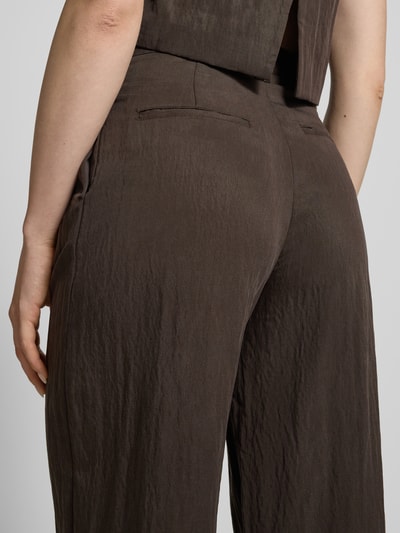 Frauenmodel trägt Hose aus Lyocell-Mix mit Paspeltaschen Modell 'ADRIAN' von Mango, braun, leicht strukturierte Textur, Ganzkörperansicht Rückansicht, Damen, Regular-Fit, Eingrifftaschen, Bundweite 37 cm, Innenbeinlänge 79 cm.