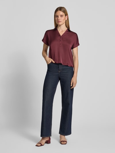 Frauenmodel trägt satinartige Damen Bluse von Vila, Modell 'ENNA RAVENNA' mit V-Ausschnitt, Knopfleiste, Ärmel mit Aufschlag, Regular-Fit, Rückenlänge 59 cm, Ganzkörperansicht von vorne.