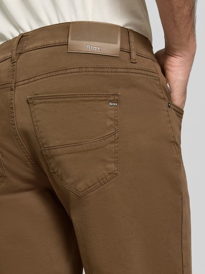 Männermodel trägt Regular Fit Weite Hose aus Baumwoll-Mix mit Lyocell-Anteil von Brax in Braun, glatte Textur, Nahaufnahme Rückansicht, Herren Weite Hose von Brax.