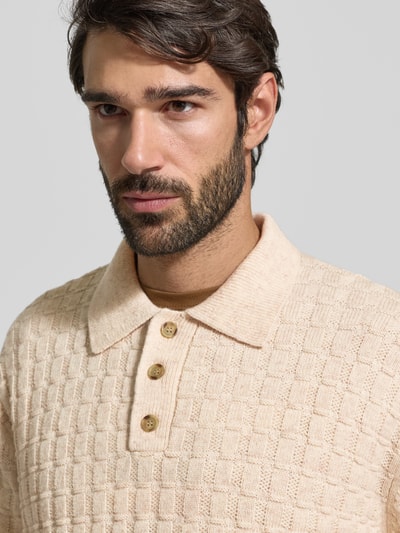 Männermodel trägt Strickpullover mit Strukturmuster Modell 'Gustav' von Les Deux aus Material-Mix mit Woll-Anteil, Polokragen, Knopfleiste, Regular-Fit, beige Farbe, Nahaufnahme Oberkörper.