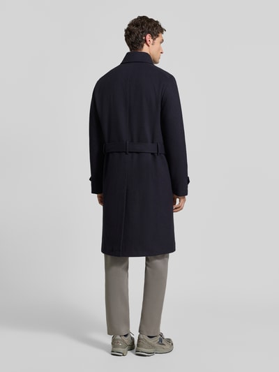 Männermodel trägt Mantel aus Viskose-Mix mit Gürtel von MCNEAL in Dunkelblau, glatte Textur, Ganzkörperansicht Rückansicht. Kontext: Regular Fit, Knopfverschluss, Zweireiher, Gürtel, Ärmelriegel, Rückenlänge bei Größe M 54 cm, Schulterbreite 46 cm, Brustweite 48 cm, Ärmellänge 66 cm.