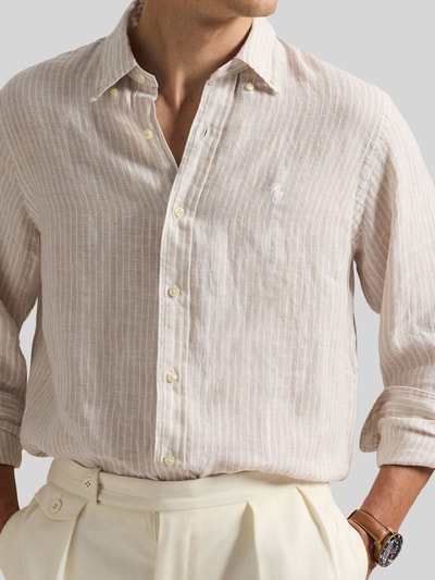 Männermodel trägt Regular Fit Freizeithemd aus reinem Leinen von Polo Ralph Lauren, Mehrfarbig, Gestreift, Flammgarn, Logo-Detail, Nahaufnahme Oberkörper.