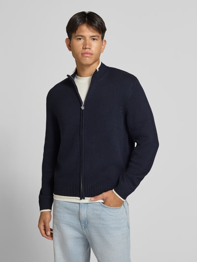 Männermodel trägt Strickjacke mit Reißverschluss Modell 'FREDERIKSBERG' von JACK & JONES, Dunkelblau, Grobstrick, Ganzkörperansicht von vorne, Regular Fit Baumwoll-Mix, gerippter Stehkragen, Kontraststreifen, Vorderansicht.