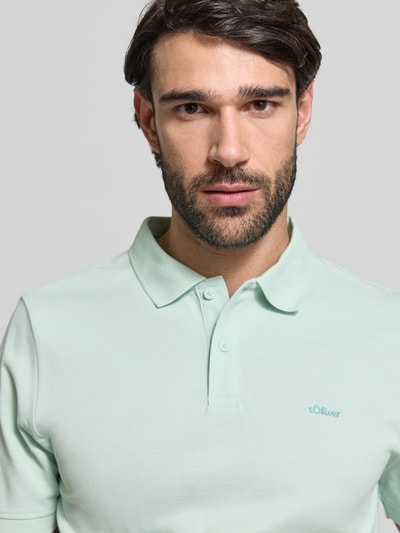Männermodel trägt Regular Fit Poloshirt aus reiner Baumwolle von s.Oliver RED LABEL in Hellgrün, unifarben, Piqué-Struktur, Nahaufnahme Oberkörper.