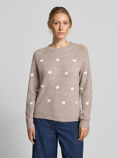 Frauenmodel trägt Regular Fit Pullover mit Rundhalsausschnitt Modell 'DOFFY' von VERO MODA in Beige mit weißen Herzmotiven, Damen Pullover, Ganzkörperansicht von vorne.