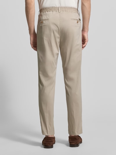 Männermodel trägt Regular Fit Stoffhose mit Logo-Detail Modell 'Lester' von JOOP! Collection in Beige, elastischer Baumwoll-Mix, Bundfalten, Gesäßtaschen, Ganzkörperansicht Rückansicht.