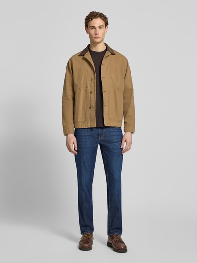 Männermodel trägt Slim Fit Jeans Modell 'ANGELS' von Guess, blauer Baumwoll-Mix mit Stretch, Eingrifftaschen, Ganzkörperansicht von vorne.