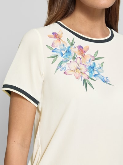 Frauenmodel trägt Regular Fit T-Shirt mit floralem Design von Christian Berg Woman Selection in Creme, Rundhalsausschnitt, Nahaufnahme Oberkörper.