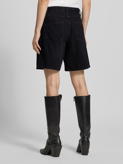 Frauenmodel trägt Regular Fit Jeansshorts aus reiner Baumwolle Modell 'LUMI' von Only in schwarzer Denim-Optik mit 5-Pocket-Design, Ganzkörperansicht Rückansicht.