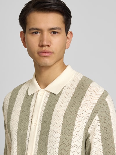 Männermodel trägt Regular Fit Poloshirt mit Knopfleiste Modell 'TYLER' von Jack & Jones im Baumwoll-Mix mit Streifenmuster, Nahaufnahme Oberkörper.