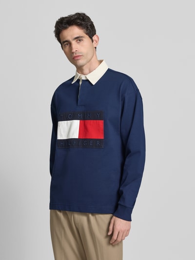 Männermodel trägt Regular Fit Sweatshirt aus reiner Baumwolle von Tommy Hilfiger in Optik: Unifarben mit Label-Patch, Ganzkörperansicht von vorne.
