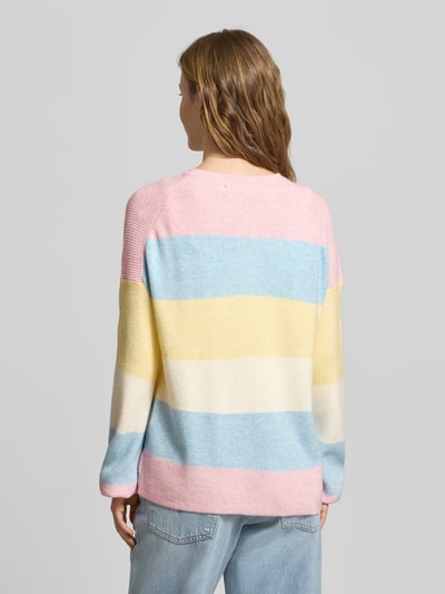 Frauenmodel trägt Regular Fit Strickpullover aus Viskose-Mix Modell 'ATIA' von Only mit mehrfarbigen Streifen, Stricktextur, Rundhalsausschnitt, langarm, Label Stitching, Ganzkörperansicht Rückansicht.