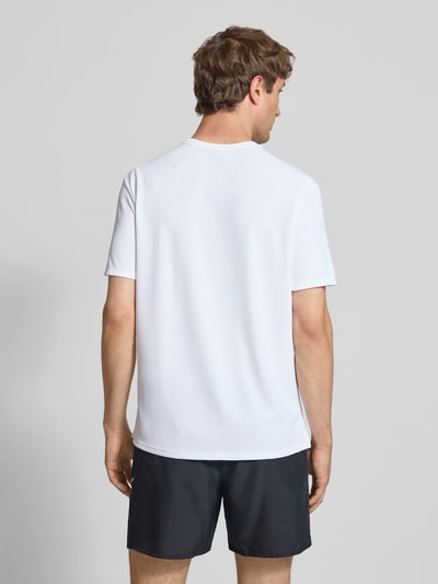 Männermodel trägt T-Shirt mit Rundhalsausschnitt und Logo von NIKE TRAINING, Regular-Fit, weiße Farbe, Rückenlänge 74 cm, Ganzkörperansicht Rückansicht.