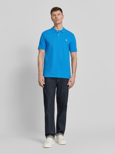 Männermodel trägt Regular Fit Poloshirt mit Knopfleiste von PAUL SMITH aus reiner Baumwolle, Stitching, Rückenlänge 76 cm, Ganzkörperansicht von vorne.