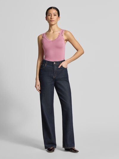 Frauenmodel trägt Slim Fit Tank Top aus Viskose-Mix Modell 'ROSA' von Vero Moda in Rosa, Optik: Unifarben, Spitzenbesatz, V-Ausschnitt, breite Träger, Ganzkörperansicht von vorne.