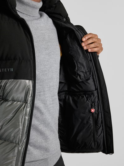 Männermodel trägt Regular Fit Steppjacke mit Stehkragen Modell 'ROYAL FLASH' von Wellensteyn, Schwarz, reflektierende Optik, Detailaufnahme Innenbereich der Jacke.