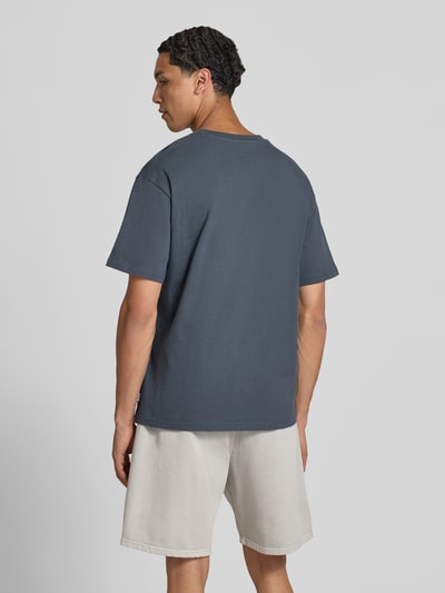 Męski model nosi Regular Fit T-Shirt mit Rundhalsausschnitt von Jack & Jones, bawełna, krój regular fit, okrągły dekolt, rękaw o dł. 1/2, długość tyłu w rozmiarze m: 70 cm, widok całej sylwetki z tyłu