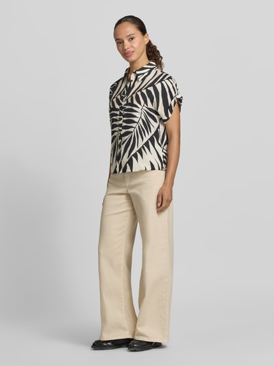 Frauenmodel trägt Bluse aus Viskose-Mix mit Hemdblusenkragen Modell 'LIFE' von Mango, gemustert in Schwarz-Beige, Straight Fit, Knopfleiste, Ärmel mit fixiertem Aufschlag, Rückenlänge bei Größe S 53 cm, Ärmellänge 15 cm, Ganzkörperansicht von vorne.
